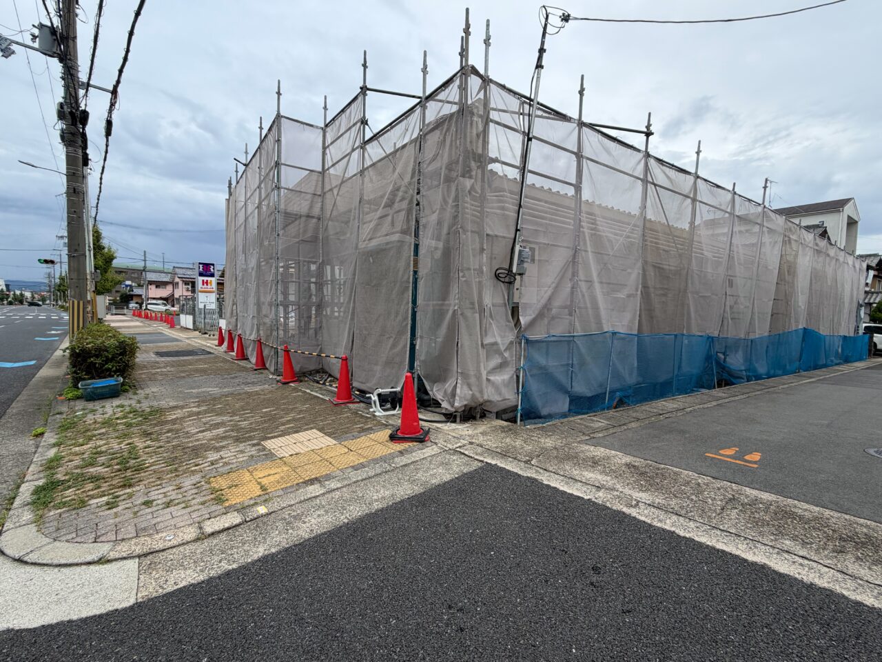 養生シートに覆われた隣接区画の工事現場