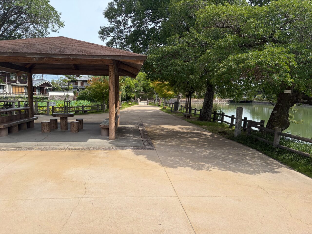 八条ヶ池のほとりに置かれた屋根付きの休憩所と水辺に続く遊歩道