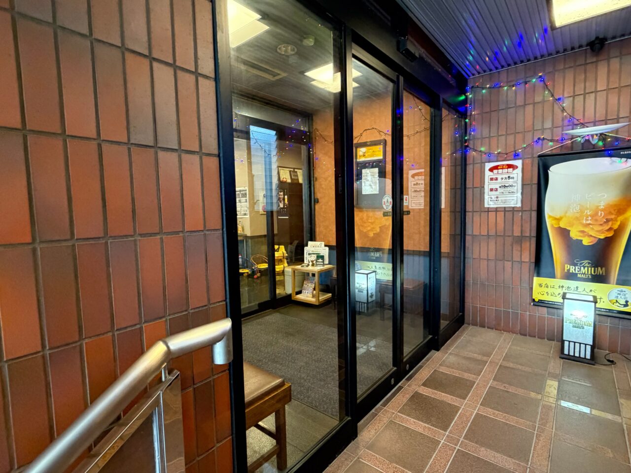 焼肉青山の入口と掲示された営業時間の案内