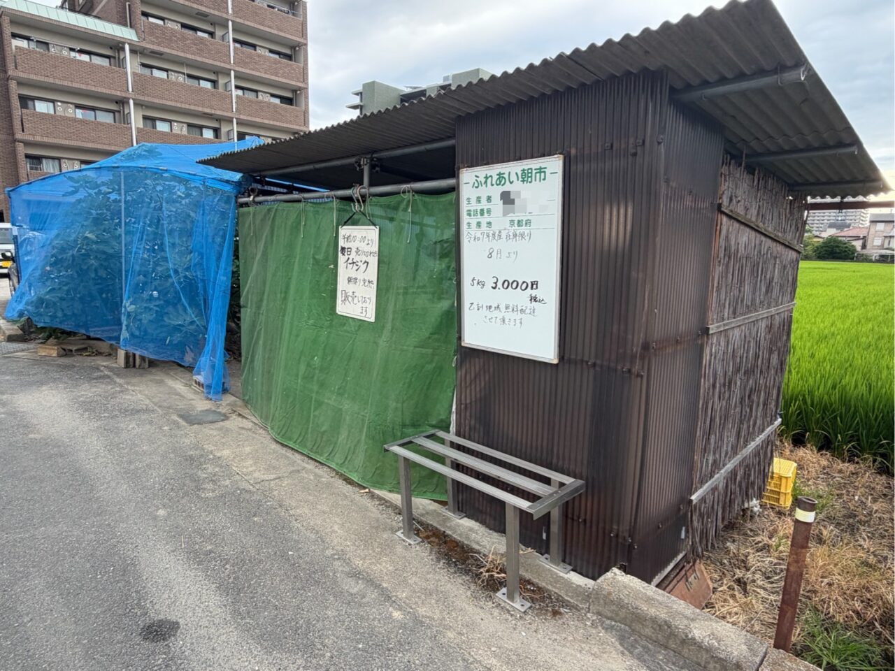 田んぼに面したふれあい朝市の直売所と掲示された案内
