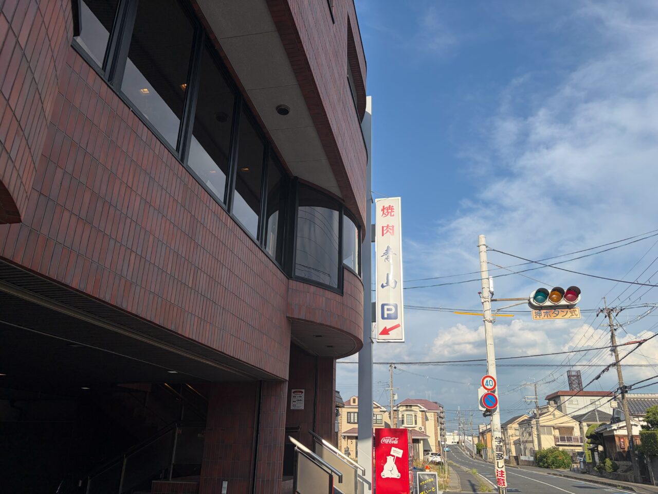 焼肉青山の建物と道路沿いに掲げられた縦長の看板