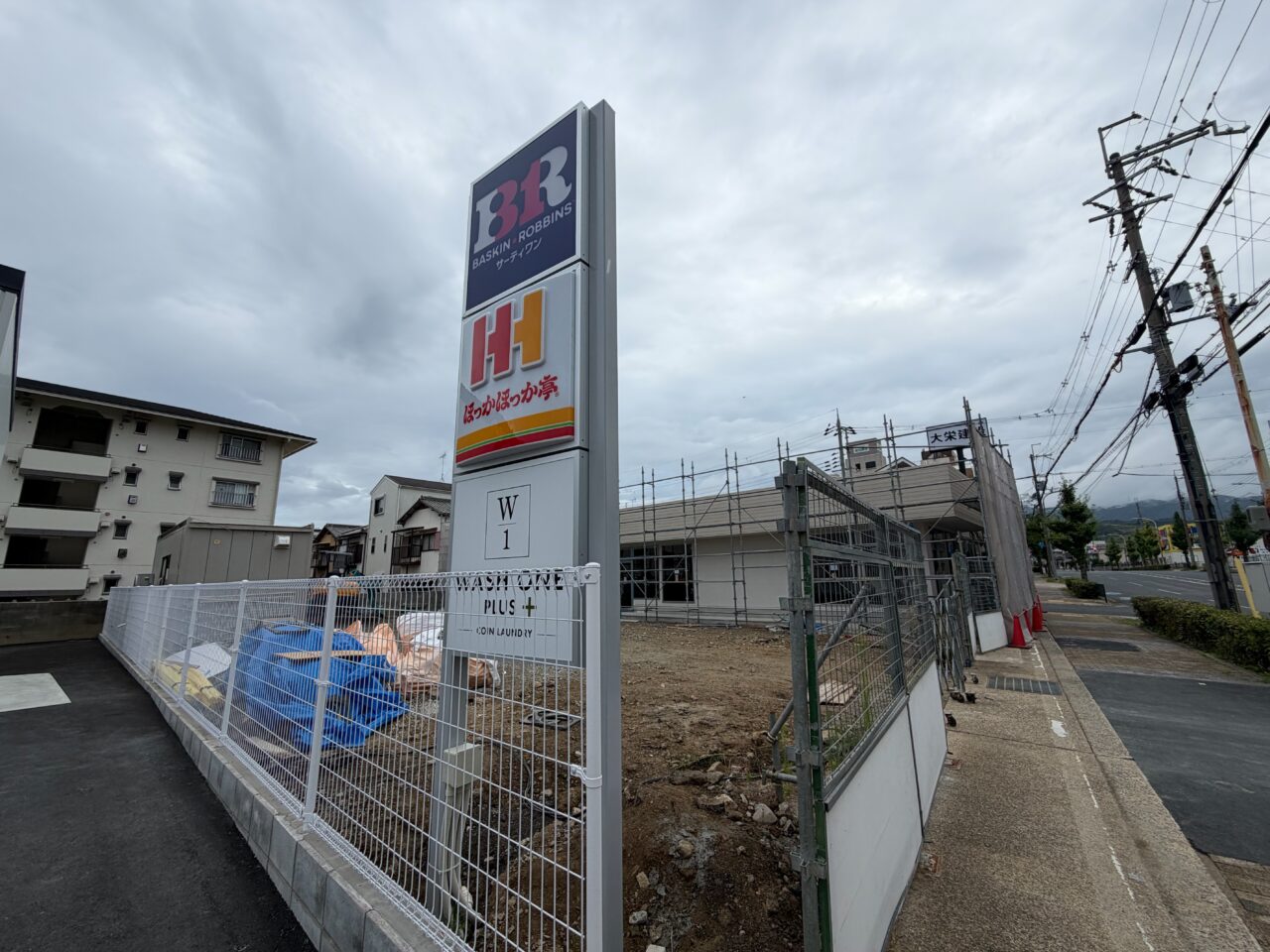 歩道沿いに立てられた3店舗の名前を記したサインポール