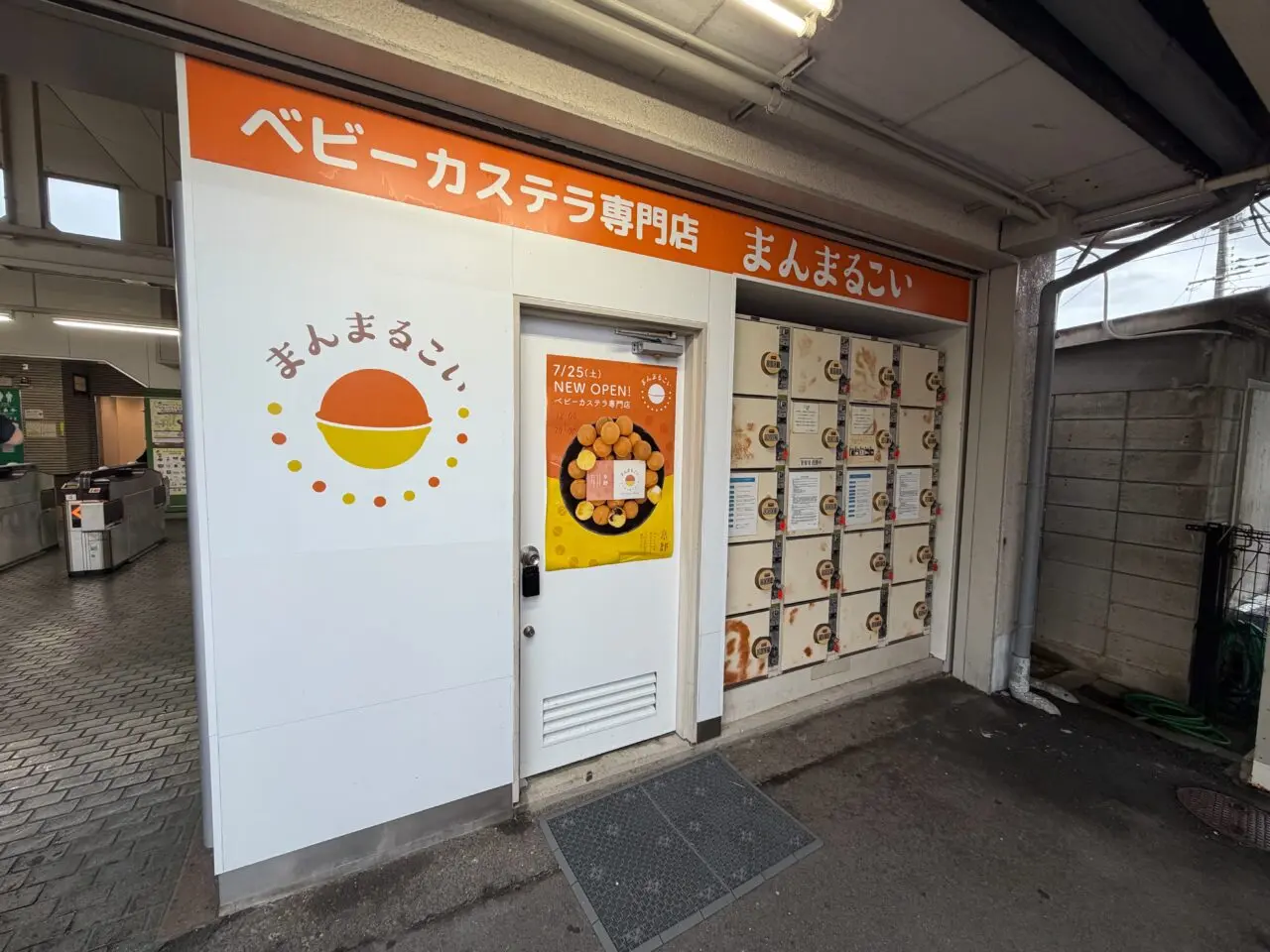 オレンジ色の看板が掲げられたベビーカステラ専門店まんまるこいの外観