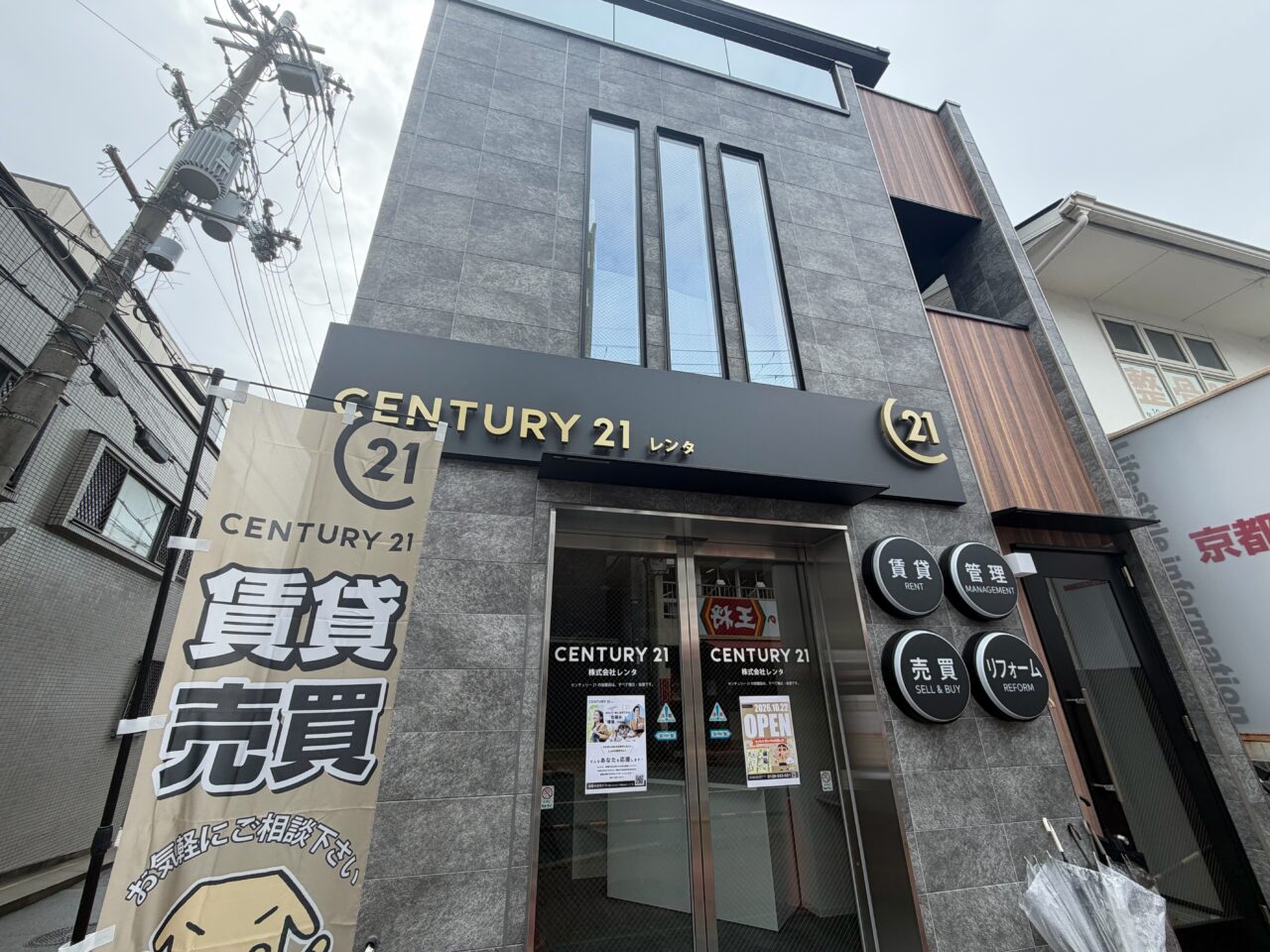 アゼリア通りに面したセンチュリー21レンタの新しい建物と移転オープンの掲示