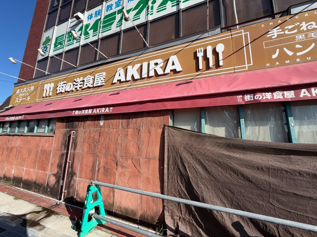 街の洋食屋AKIRAの店名が掲げられた看板